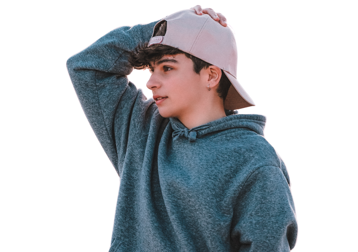 teenage boy with his hand on his head, wearing a baseball cap