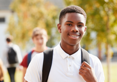 male teenager wearing a white top and a backpack