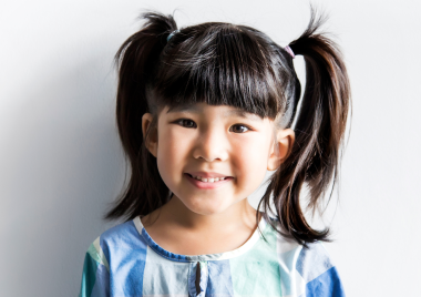 little girl smiling with pigtails in her hair