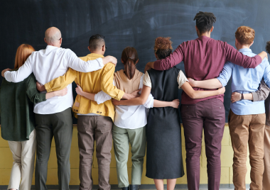 group of people looking away with their arms around each other