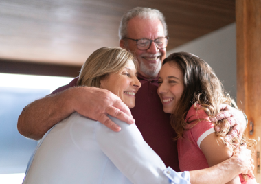 grandparents hugging teenager