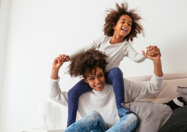 child sitting on adults shoulders