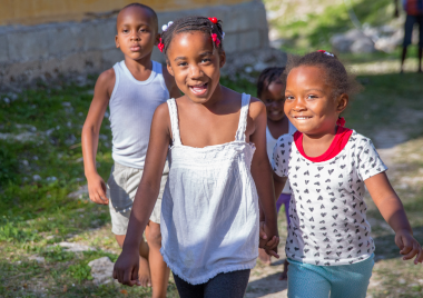 3 children of african and carribean heritage playing in the sun