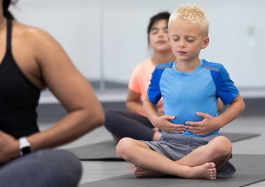 Boy breathing on a yoga mat