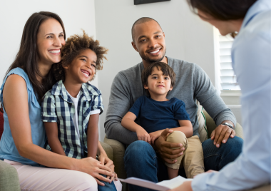 Two adults and two children talking to a supervising social worker