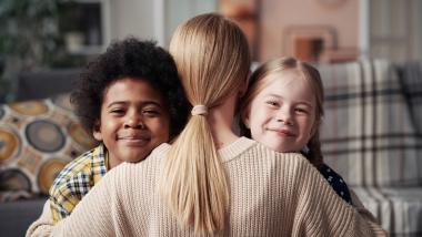 Adult hugging children