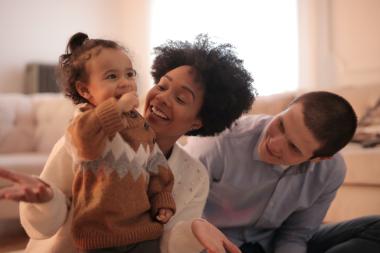 A child playing with two young adults