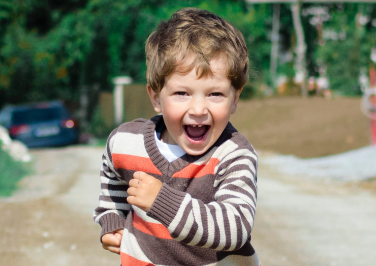little boy with mouth open in a running pose